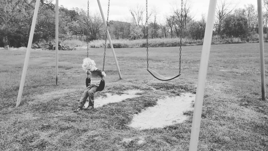 boy swinging alone