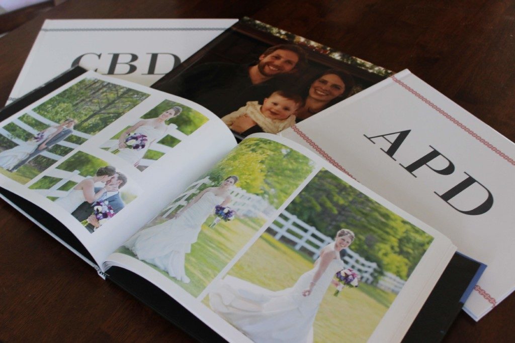 a pile of four photo books with one open to wedding pictures