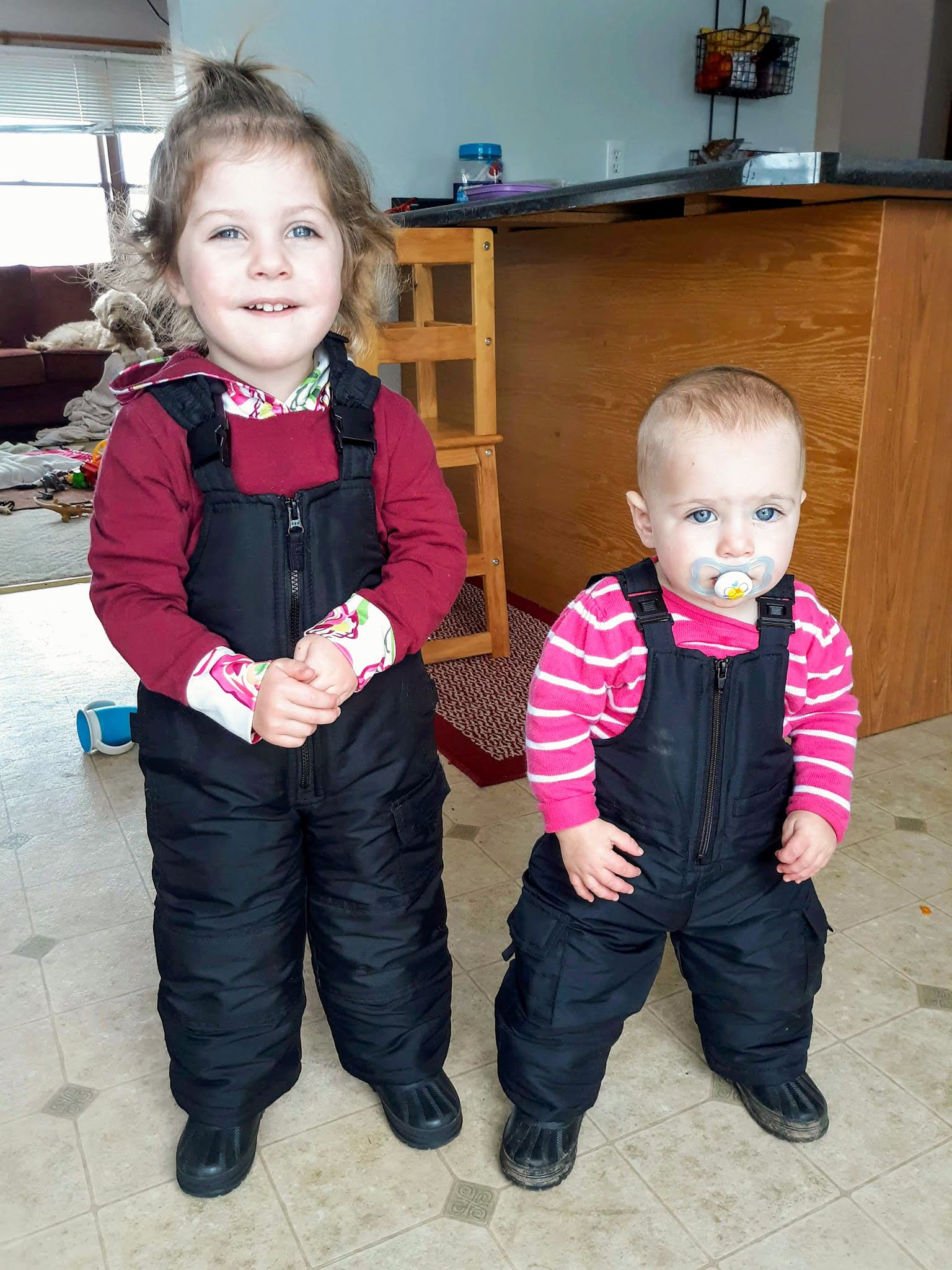 toddlers in snowpants and snowboots