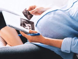 pregnant woman looking at ultrasound photos