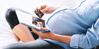 pregnant woman looking at ultrasound photos