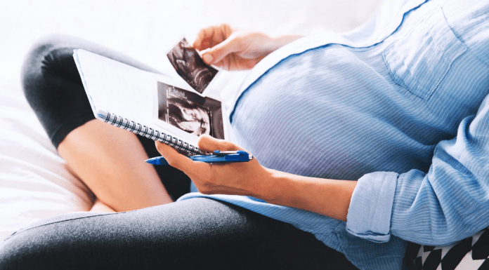 pregnant woman looking at ultrasound photos