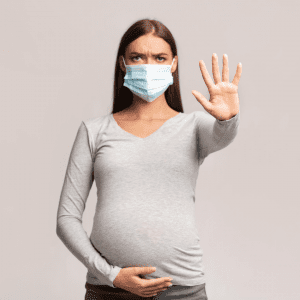 pregnant woman wearing face mask with hand out